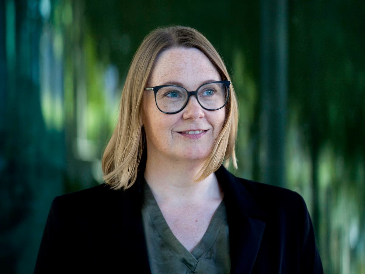 placeholder-image Lene Stampe, står foran store vinduer, hvor grønt ved spejler sig. Lene arbejder med konflikthåndtering i virksomheder